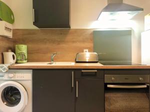 a kitchen with a sink and a washing machine at T2 entièrement équipé et refait à neuf à 10mn Alès in La GrandʼCombe