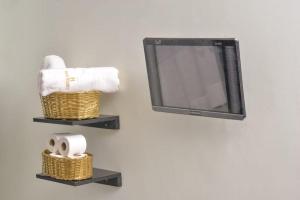 a bathroom with two baskets and a tv on a wall at Boujee Residence Apartment in Kampala +17 photos