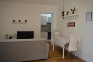a living room with a white table and a kitchen at Casa SoleLuna - alloggio turistico Rome Airport in Fiumicino +7 photos