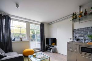 uma sala de estar com um sofá e uma cozinha com uma janela em Apartment Mini-Loft am Schloss em Raesfeld