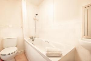 een witte badkamer met een toilet en een bad bij BEST PRICE! STUNNING 2 Bed City Centre - 4 single beds or 2 Super king, Smart TVs, Sofa Bed & FREE SECURE PARKING in Southampton