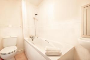 a white bathroom with a toilet and a bath tub at BEST PRICE! STUNNING 2 Bed City Centre - 4 single beds or 2 Super king, Smart TVs, Sofa Bed & FREE SECURE PARKING in Southampton