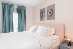 1 dormitorio con cama blanca y cortinas verdes en Moderno piso en Las Palmas de Gran Canaria en Las Palmas de Gran Canaria