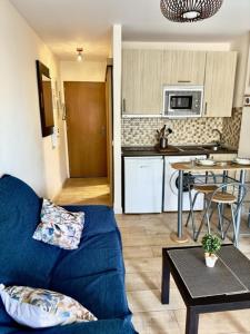 a living room with a blue couch and a kitchen at Apartamento Marysol in Benalmádena