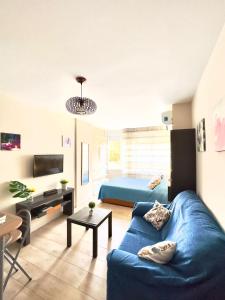 un soggiorno con divano blu e letto di Apartamento Marysol a Benalmádena