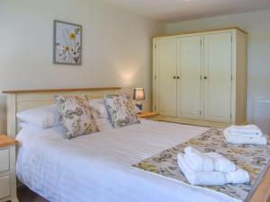 ein Schlafzimmer mit einem großen weißen Bett mit Handtüchern darauf in der Unterkunft Outhwaite Cottage in Scalehouses