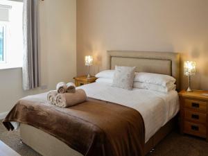 a bedroom with a large bed with towels on it at Liftingstane Dairy Cottage in Closeburn