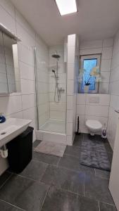 een badkamer met een douche, een toilet en een wastafel bij Apartments in Schöner Lage in Mönchengladbach in Mönchengladbach