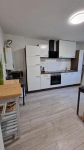 a large kitchen with white cabinets and a wooden floor at Apartments in Schöner Lage in Mönchengladbach in Mönchengladbach