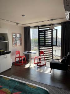 a living room with red chairs and a table at Vintage Lofts in Guadalajara +5 photos