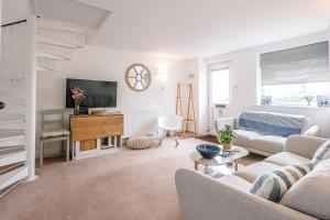 ein Wohnzimmer mit einem Sofa und einem TV in der Unterkunft Coasters in Aldeburgh