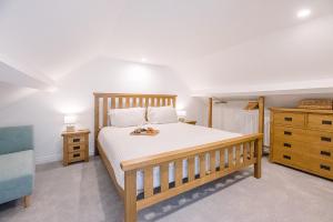 ein Schlafzimmer mit einem Holzbett und einer Kommode in der Unterkunft Coasters in Aldeburgh