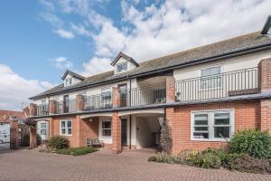 a brick building with a balcony on top of it at Coasters, Aldeburgh in Aldeburgh