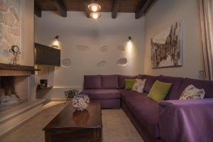 een woonkamer met een paarse bank en een open haard bij Villa Zefi in Elefterna