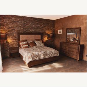 a bedroom with a bed and a brick wall at Apartmány Pekárna 1898 in Beroun