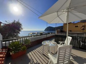 a patio with a table and chairs and an umbrella at Casa MARINELLA in Lipari