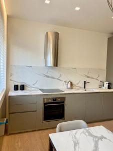 a kitchen with white marble counters and a sink at Torino 64 - Duomo City Center Luxury Apt Perfect x2! Self Check-In in Milan