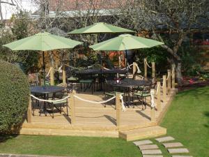 a wooden deck with tables and chairs and umbrellas at Sonachan House in Paignton