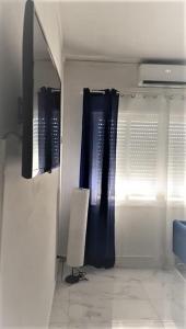 Un armario con cortinas azules y una lámpara en una habitación. en Atmosfera B&B al centro della città, en Cosenza