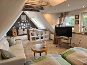 a living room with a couch and a tv at Stylisches Garden Cottage in Weyhe
