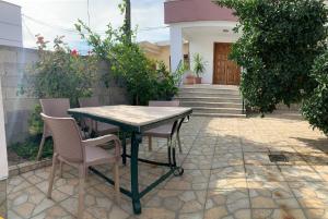 a table and chairs on a patio in front of a house at Shtepi Me qera Fier in Fier