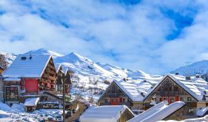 een stad bedekt met sneeuw met bergen op de achtergrond bij Borgo Stalle Residence in Prato Nevoso