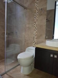 uma casa de banho com um WC, um chuveiro e um lavatório. em Girardot Casa estilo mediterraneo con piscina privada em Girardot