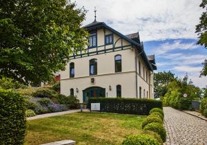 a large white house with a cross on the roof at Das Elbcottage - Remise am Süllberg - Boarding House in Hamburg