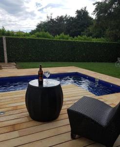 Una botella de vino sentada en una mesa junto a una piscina en Girardot Casa estilo mediterraneo con piscina privada en Girardot