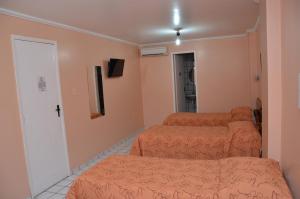 a room with three beds with orange sheets at Hotel Vivo in Garanhuns +20 photos