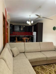 a living room with a couch and a kitchen at Shtepi Me qera Fier in Fier