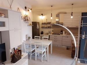 Tiny Green apartament in Rome - Magliana في روما: مطبخ مع طاولة بيضاء وكراسي