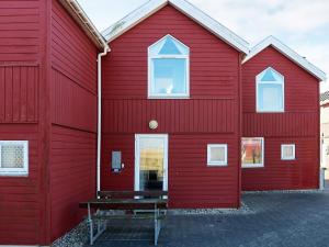 Apartment Hadsund IX في Hadsund: مبنى احمر امامه مقعد