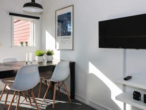 Apartment Hadsund IX في Hadsund: غرفة طعام مع طاولة وتلفزيون بشاشة مسطحة