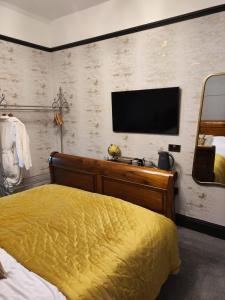 ein Schlafzimmer mit einem Bett und einem TV an der Wand in der Unterkunft The Ribchester Arms in Blackburn