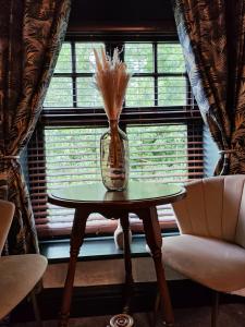 um vaso sobre uma mesa em frente a uma janela em The Ribchester Arms em Blackburn
