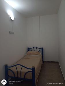 a small bedroom with a bed in a white room at Lugar Encantador con estacionamiento gratuito. in Olavarría