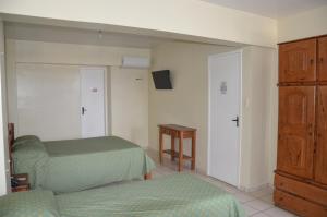 a bedroom with two twin beds and a dresser at Hotel Vivo in Garanhuns