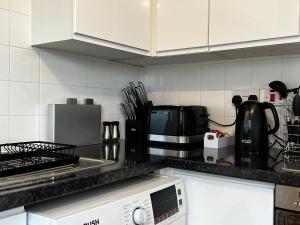 a kitchen with a counter top with a microwave at River View Apartment - Central Dundee - Free Private Parking - Sky & TNT Sports - Lift Access - Superfast WIFI - Quiet Neighbourhood - 2 Bathrooms - Amazing Views - Balcony & Courtyard - Long Stays Welcome in Dundee +12 photos