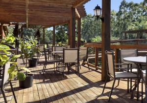 a patio with tables and chairs on a wooden deck at Hotel Acqua Lokos in Capão da Canoa