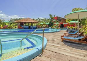 una piscina in un resort con sedie e ombrelloni di Hotel Acqua Lokos a Capão da Canoa