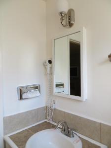 een badkamer met een wastafel en een spiegel bij Capri Motel in Santa Clara