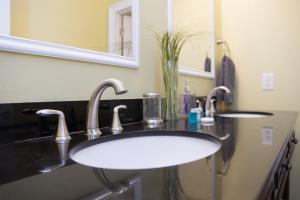 a bathroom sink with two faucets and a mirror at Very Nice 3BR 2BA Balcony & Peaceful Neighborhood -H- in Moss Point +20 photos