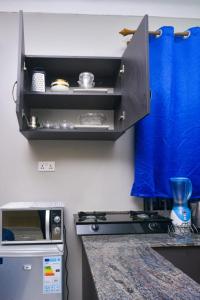 a kitchen with a counter with a stove top oven at Boujee Residence Apartment in Kampala