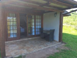 a screened in porch of a house with a table at Rain Farm Game Lodge in uMhlali