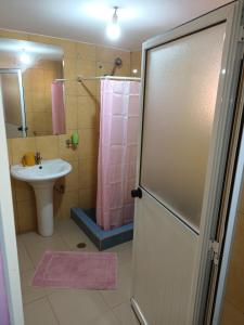 ein Bad mit einem Waschbecken und einer Dusche mit einem Duschvorhang in der Unterkunft HOTEL BADINCA Alojamento Low Cost in Bissau avenida FRANCISCO MENDES in Bissau