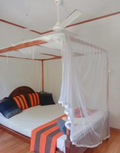 a bedroom with a bed with a ceiling fan at Romaclan Villa in Midigama East