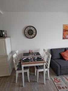 uma mesa e cadeiras numa sala de estar com um sofá em Dahls Ferienwohnung em Sankt Andreasberg