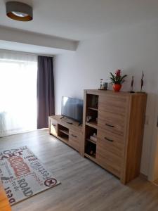 uma sala de estar com televisão e uma cómoda de madeira em Dahls Ferienwohnung em Sankt Andreasberg