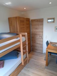 a room with two bunk beds and a table at Dahls Ferienwohnung in Sankt Andreasberg